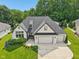 Aerial view of a well-kept, light brick home featuring a large lawn and a three-car garage at 5572 Harness Dr, Greenwood, IN 46143