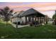 A spacious backyard featuring a screened in porch, lush lawn, and mature trees at 5572 Harness Dr, Greenwood, IN 46143