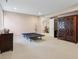 A finished basement is spacious with neutral walls, carpet, and access to other rooms at 5572 Harness Dr, Greenwood, IN 46143