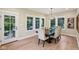 Well-lit dining room with a dark wood table, upholstered chairs, and natural light from large windows at 5572 Harness Dr, Greenwood, IN 46143