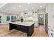 Modern kitchen features an island with a sink, white cabinets, stainless steel appliances and wood floors at 5572 Harness Dr, Greenwood, IN 46143