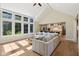 Open concept living room with large windows, vaulted ceiling and view into kitchen with island at 5572 Harness Dr, Greenwood, IN 46143