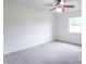 Clean, sunlit bedroom with neutral carpet, a ceiling fan, and a large window with tree view at 5602 Northport Dr, Indianapolis, IN 46221