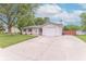 Charming single-story home featuring white siding, red shutters, and an attached one-car garage on a concrete driveway at 5602 Northport Dr, Indianapolis, IN 46221
