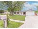 Street view of home showing well-manicured lawn, white siding, and updated mailbox at 5602 Northport Dr, Indianapolis, IN 46221