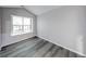 Neutral-toned bedroom featuring vaulted ceiling, wood-look floors, and a bright window at 5633 Fox Glove Ln, Indianapolis, IN 46254