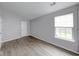 A bright bedroom featuring gray walls, wood-look flooring and a window with white blinds at 5633 Fox Glove Ln, Indianapolis, IN 46254