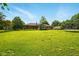 Spacious backyard featuring manicured lawn, mature trees and trampoline at 564 Penright Ct, Indianapolis, IN 46217