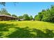 A large backyard features a spacious lawn, mature trees and trampoline at 564 Penright Ct, Indianapolis, IN 46217