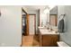 Bathroom with dual sinks, wooden cabinets, and wood-look flooring at 564 Penright Ct, Indianapolis, IN 46217