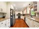 Kitchen featuring hardwood floors, white cabinets, stainless steel appliances, and great lighting at 564 Penright Ct, Indianapolis, IN 46217