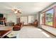 Large living room featuring wood-framed windows, a stone fireplace, and plush carpeting at 564 Penright Ct, Indianapolis, IN 46217