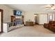 Cozy living room featuring a stone fireplace, storage cabinet, and neutral carpeting at 564 Penright Ct, Indianapolis, IN 46217