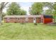 Expansive backyard with lush lawn, brick home, patio set, firepit and red shed at 5889 W Homestead Dr, Frankton, IN 46044