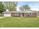 Charming brick home featuring a well-maintained lawn, inviting facade, and attached garage at 5889 W Homestead Dr, Frankton, IN 46044