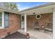 Charming front porch with brick facade, decorative seating, and well-maintained landscaping at 5889 W Homestead Dr, Frankton, IN 46044
