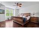 Spacious bedroom with a large window, hardwood floors, a ceiling fan, and a comfortable king-sized bed at 589 Viking Warrior Blvd, Westfield, IN 46074