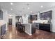 Gourmet kitchen featuring a large island, dark cabinets, stainless steel appliances, and hardwood floors at 589 Viking Warrior Blvd, Westfield, IN 46074