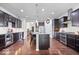 Spacious kitchen with dark cabinetry, granite countertops, stainless appliances, and hardwood floors at 589 Viking Warrior Blvd, Westfield, IN 46074