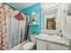 Bathroom with blue walls, white cabinets, granite-style counters and floral shower curtain at 6627 Cobden Ct, Indianapolis, IN 46254