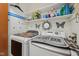 Laundry room with two washers and dryers, overhead storage and decorative accents at 6627 Cobden Ct, Indianapolis, IN 46254