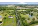 Picturesque aerial view of a sprawling estate with mature trees, rolling lawns, ponds, and a long driveway at 6630 Travis Rd, Greenwood, IN 46143