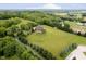 A beautiful aerial view of an estate with a long driveway, surrounding trees, and expansive manicured lawn at 6630 Travis Rd, Greenwood, IN 46143