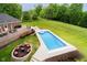 An aerial view showcasing a home's backyard with a pool, fire pit, and patio area at 6630 Travis Rd, Greenwood, IN 46143