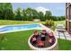 Backyard oasis with a sparkling pool, fire pit area, and well-manicured landscaping at 6630 Travis Rd, Greenwood, IN 46143