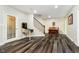 Open basement area with luxury vinyl flooring, leading to stairs, a pinball machine, and a piano at 6630 Travis Rd, Greenwood, IN 46143