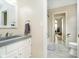 Bathroom featuring a gray granite vanity, modern fixtures, and views into other rooms of the home at 6630 Travis Rd, Greenwood, IN 46143