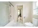 Bright bathroom featuring modern fixtures, granite tile, and an adjacent view into a sunlit room at 6630 Travis Rd, Greenwood, IN 46143