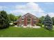 Striking two-story brick home with grand entrance and lush landscaping at 6630 Travis Rd, Greenwood, IN 46143
