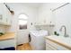 Bright laundry room with washer, dryer, sink, and storage cabinets at 6630 Travis Rd, Greenwood, IN 46143