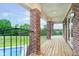 Covered porch area with brick columns, overlooking a meticulously landscaped yard and pool at 6630 Travis Rd, Greenwood, IN 46143