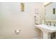 Stylish powder room with a pedestal sink, decorative mirror, and neutral paint at 6630 Travis Rd, Greenwood, IN 46143