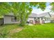 Cozy home backyard with a wooden deck, mature trees, and green grass at 6737 Raritan Dr, Indianapolis, IN 46221