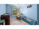 This cozy bedroom features a blue walls, carpeted floors, a large window and a comfortable armchair at 6737 Raritan Dr, Indianapolis, IN 46221