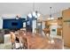 Open-concept dining area with vaulted ceilings, wood table, and adjacent living room at 6737 Raritan Dr, Indianapolis, IN 46221