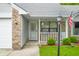 Inviting front porch with decorative hanging flowers and an American flag at 6737 Raritan Dr, Indianapolis, IN 46221