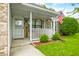 Inviting front porch with decorative hanging flowers and an American flag at 6737 Raritan Dr, Indianapolis, IN 46221