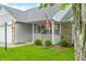 Inviting front porch with decorative hanging flowers and an American flag at 6737 Raritan Dr, Indianapolis, IN 46221