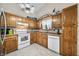 Cozy kitchen with white appliances, wood cabinetry, and natural lighting creates a warm and inviting atmosphere at 6737 Raritan Dr, Indianapolis, IN 46221