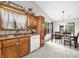 Functional kitchen and dining area with wood cabinets, double sink, and view to dining area, perfect for Gathering meals at 6737 Raritan Dr, Indianapolis, IN 46221