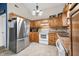 Well-maintained kitchen with classic wood cabinetry, stainless steel refrigerator, and functional layout for culinary enthusiasts at 6737 Raritan Dr, Indianapolis, IN 46221