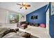 Cozy living room featuring a large window, plush sectional sofa and statement blue wall adding a pop of color at 6737 Raritan Dr, Indianapolis, IN 46221