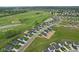 Stunning aerial view of a Primary-planned community, showcasing lush green spaces, a pond, and well-maintained homes at 7051 E Bean Blossom Dr, Camby, IN 46113
