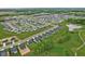 Expansive aerial view of a residential area, featuring meticulously planned homes, a scenic pond, and a tranquil setting at 7051 E Bean Blossom Dr, Camby, IN 46113