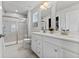 Bright bathroom featuring a double sink vanity, framed mirrors, and glass shower at 7051 E Bean Blossom Dr, Camby, IN 46113