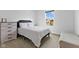 Cozy bedroom with a bed, dresser, and natural light streaming in from a window at 7051 E Bean Blossom Dr, Camby, IN 46113